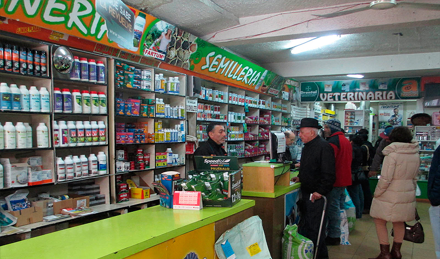 Interior de ACOMA con sección de semillería y veterinaria atendiendo a clientes