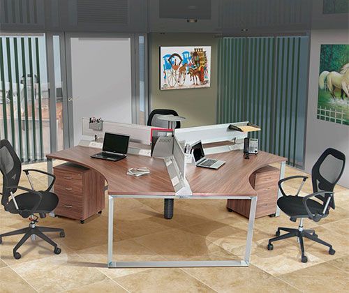 Estaciones de trabajo modulares con escritorios en L, sillas verdes y libreros en oficina de espacio abierto