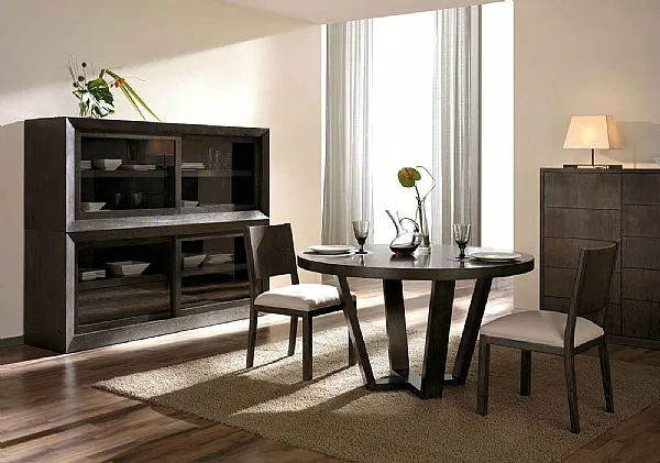 Mesa de comedor redonda en madera oscura con sillas tapizadas y aparador al fondo, colección de ArtesMoble