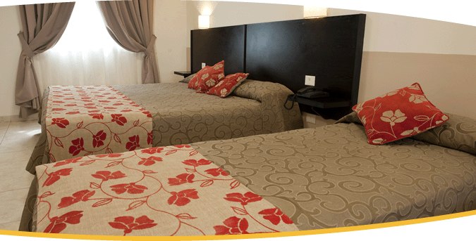 Departamento Doble con dos camas vestidas en tonos rojo y blanco