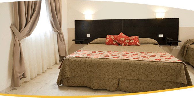 Departamento Estándar con cama matrimonial y almohadones florales