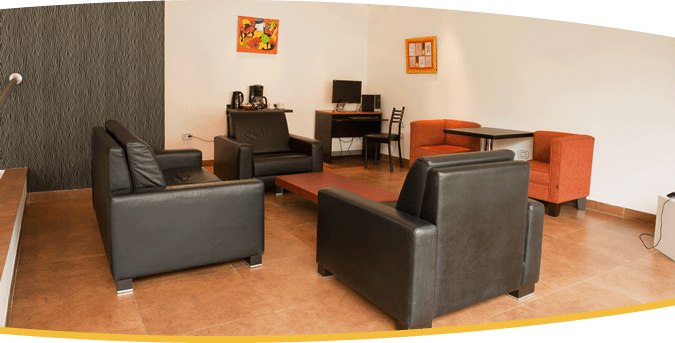 Sala de estar de Astro Apart Hotel con sillones de cuero, escritorio y cuadros de colores