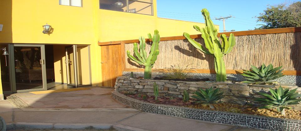 Pasillo exterior de habitaciones de Atacama Lodge con estacionamiento propio junto a cada puerta