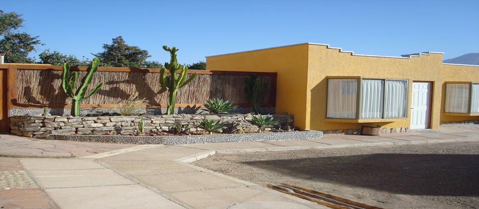 Segundo patio de Atacama Lodge con jardín de cactus y muro de piedra