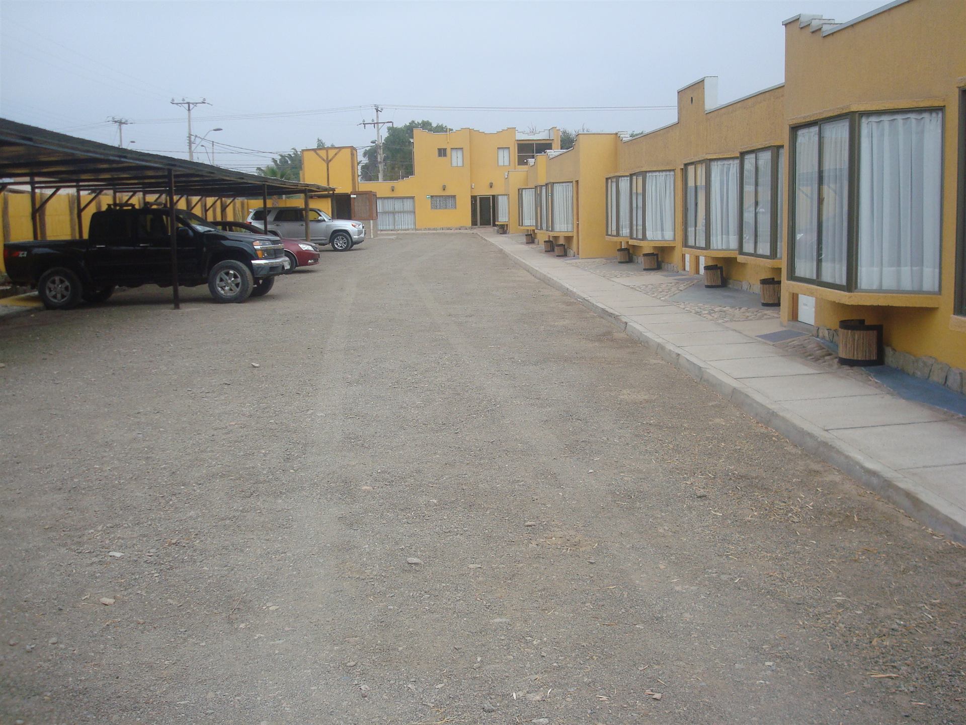 Pasillo exterior de habitaciones de Atacama Lodge con estacionamiento propio