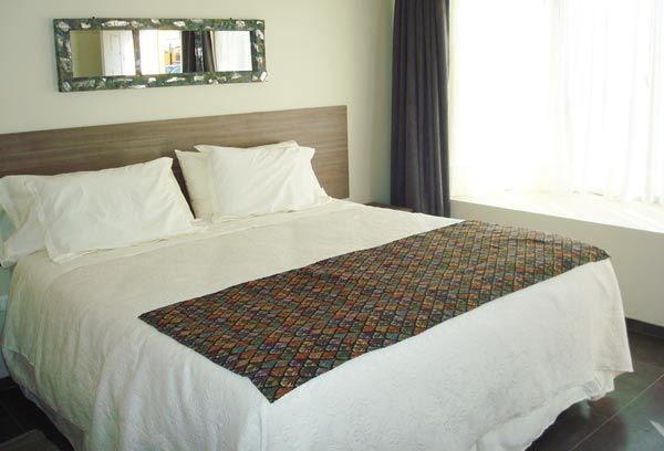Habitación Standard de Atacama Lodge con cama matrimonial y espejo artesanal
