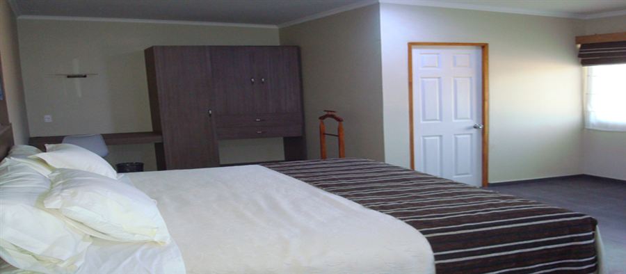 Habitación Superior de Atacama Lodge con cama, escritorio y clóset de madera