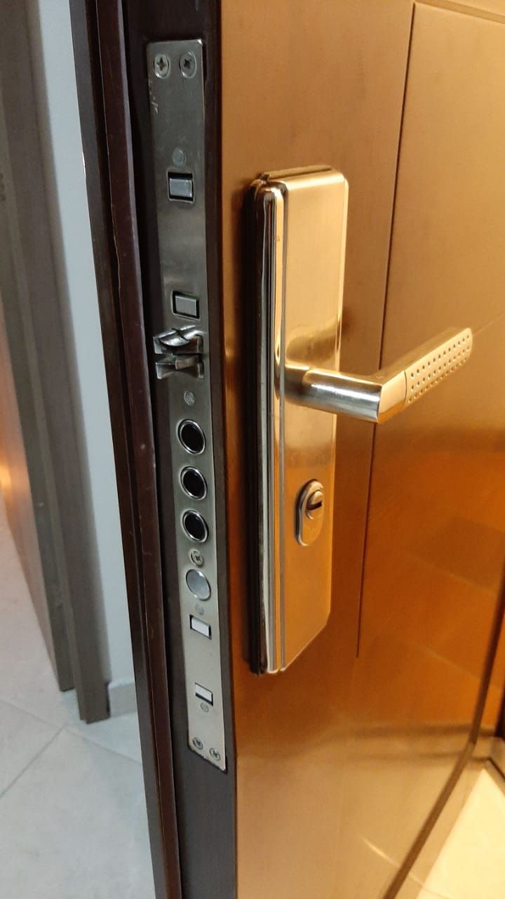 Técnico de Llaves 24 Horas instalando una cerradura digital con teclado en una puerta de madera en Medellín
