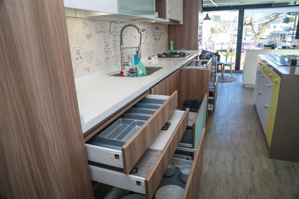 Cocina a medida con cajones organizadores abiertos y vista a la calle, fabricada por Chilemuebles