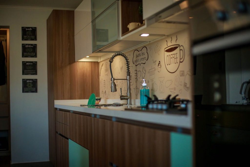 Detalle de cocina a medida con grifería y respaldo decorado, fabricada por Chilemuebles