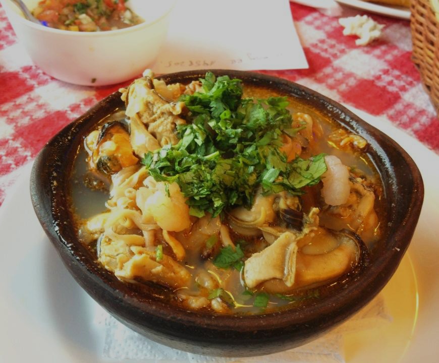 Caldillo marino en paila de greda con mariscos, pescado y cilantro fresco