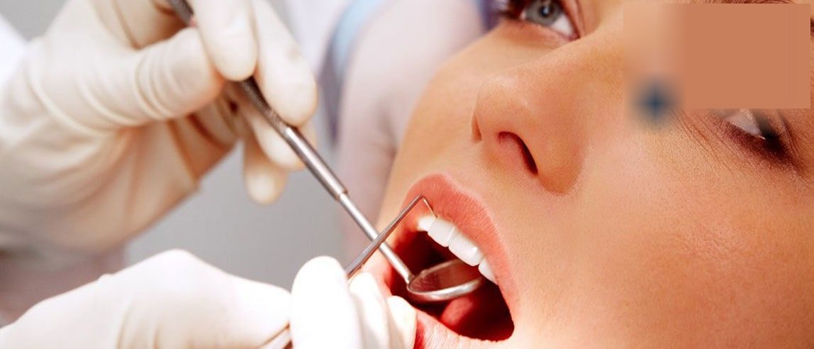 Odontólogo atendiendo a una paciente en box de la Clínica Dental Antofagasta