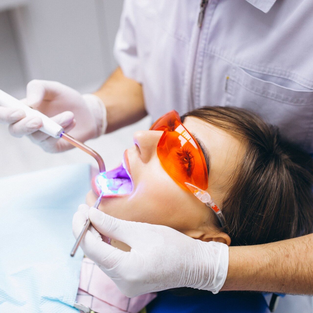 Aplicação de clareamento dental com luz LED em atendimento odontológico