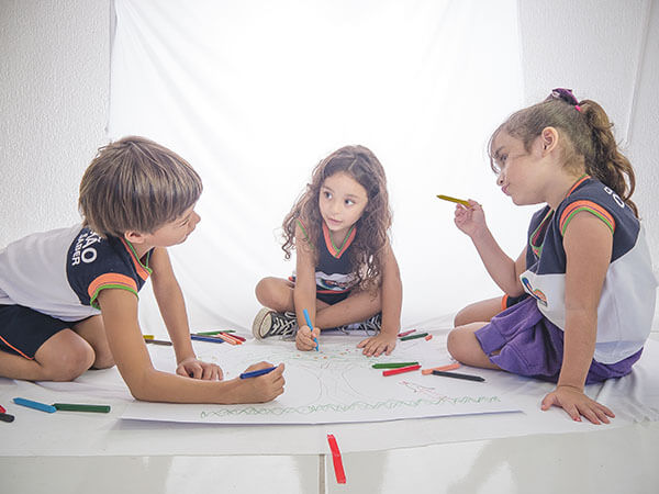 Crianças da Educação Infantil desenhando juntas em atividade pedagógica no Colégio Conexão Saber