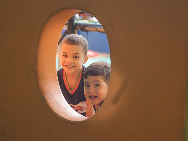 Alunos sorrindo em brincadeira no parque do Colégio Conexão Saber