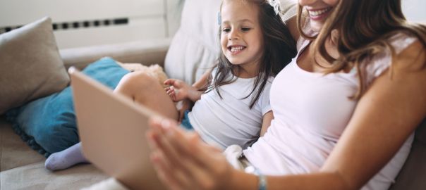 Criança sorrindo durante um momento de leitura e estímulo à Educação Infantil