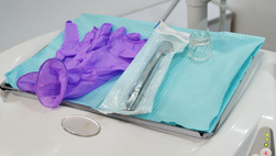 Campo estéril preparado con guantes e instrumental antes de un procedimiento dental