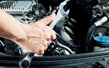 Mecânico trabalhando com chave no compartimento do motor
