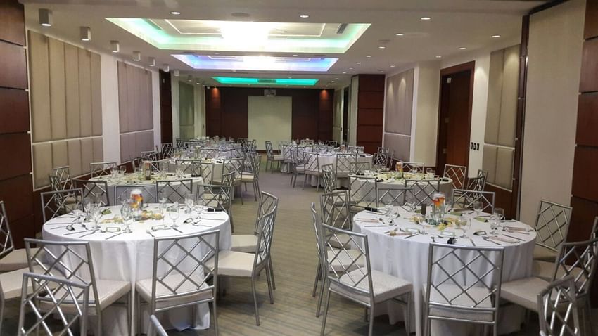 Salón de banquetes de The Executive Hotel con mesas redondas dispuestas para un evento corporativo