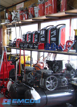 Compresores y motores en exhibición en Ferretería EMCOB, con estanterías de maquinaria y equipos al fondo