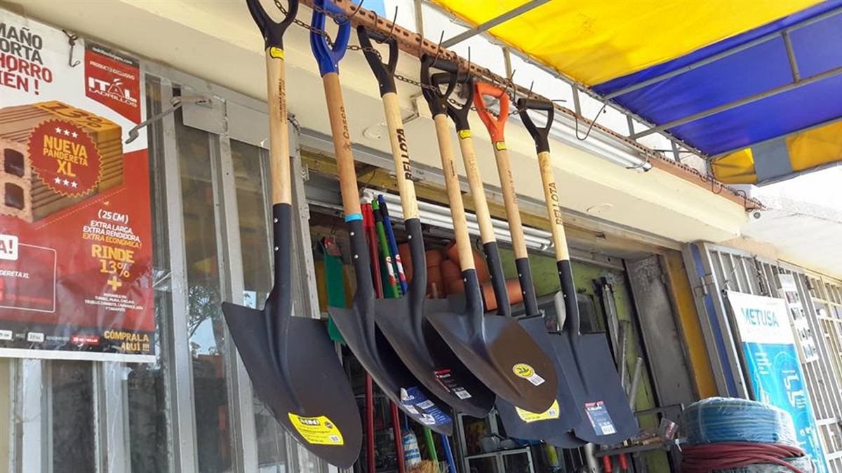 Fachada de la sucursal de Ferretería Gamboa en Trujillo, con palas y herramientas colgadas bajo el toldo de la tienda