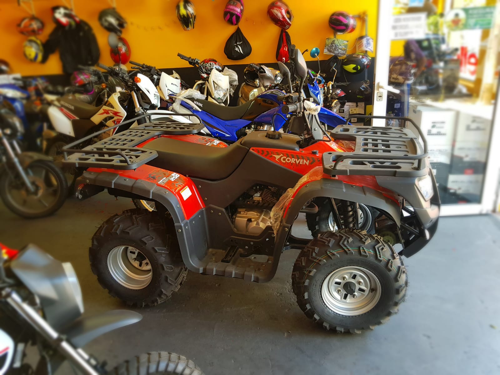 Cuatriciclo Corven junto a motos en el showroom de GAB Motors