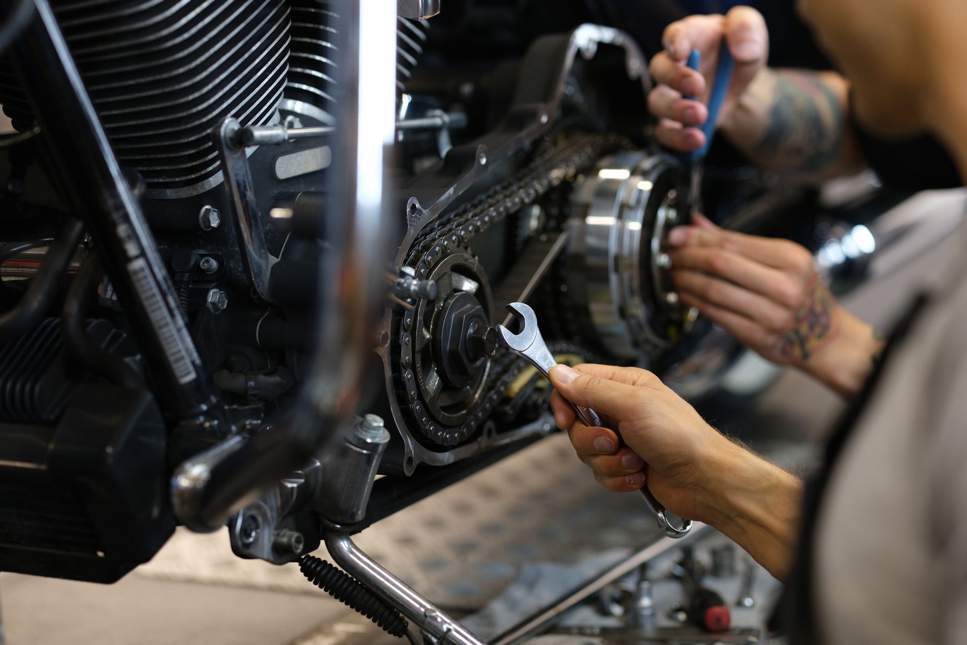 Mecánico de GAB Motors reparando la transmisión de una motocicleta con herramientas