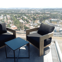 Sillones de exterior en terraza con vista a la ciudad, mobiliario a medida