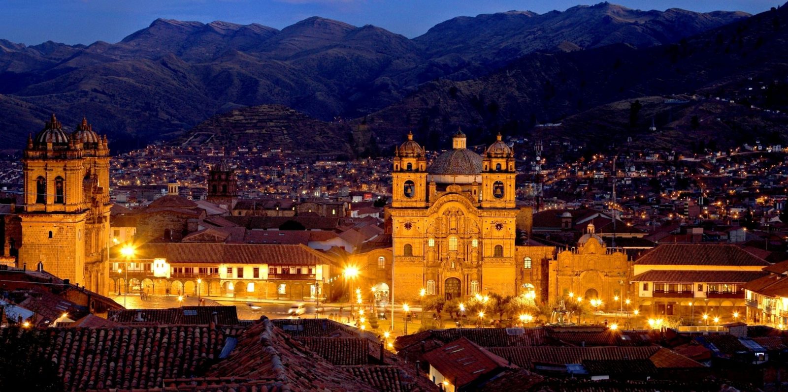 Vista nocturna del Centro Histórico de Cusco, con la Plaza de Armas iluminada y los Andes de fondo