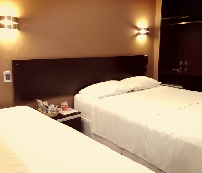 Habitación del Hostal Elixer con cortinas cálidas y mesa de trabajo junto a la ventana