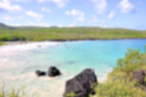 Bahía de aguas turquesas con rocas volcánicas en la costa de San Cristóbal, Galápagos