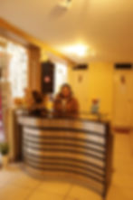 Recepción del Hostal Flor Andina atendiendo a un huésped