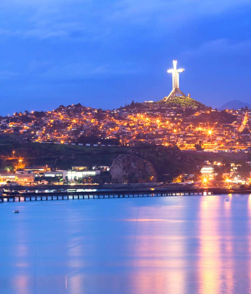 Cruz del Tercer Milenio iluminada de noche en Coquimbo, vista desde la bahía