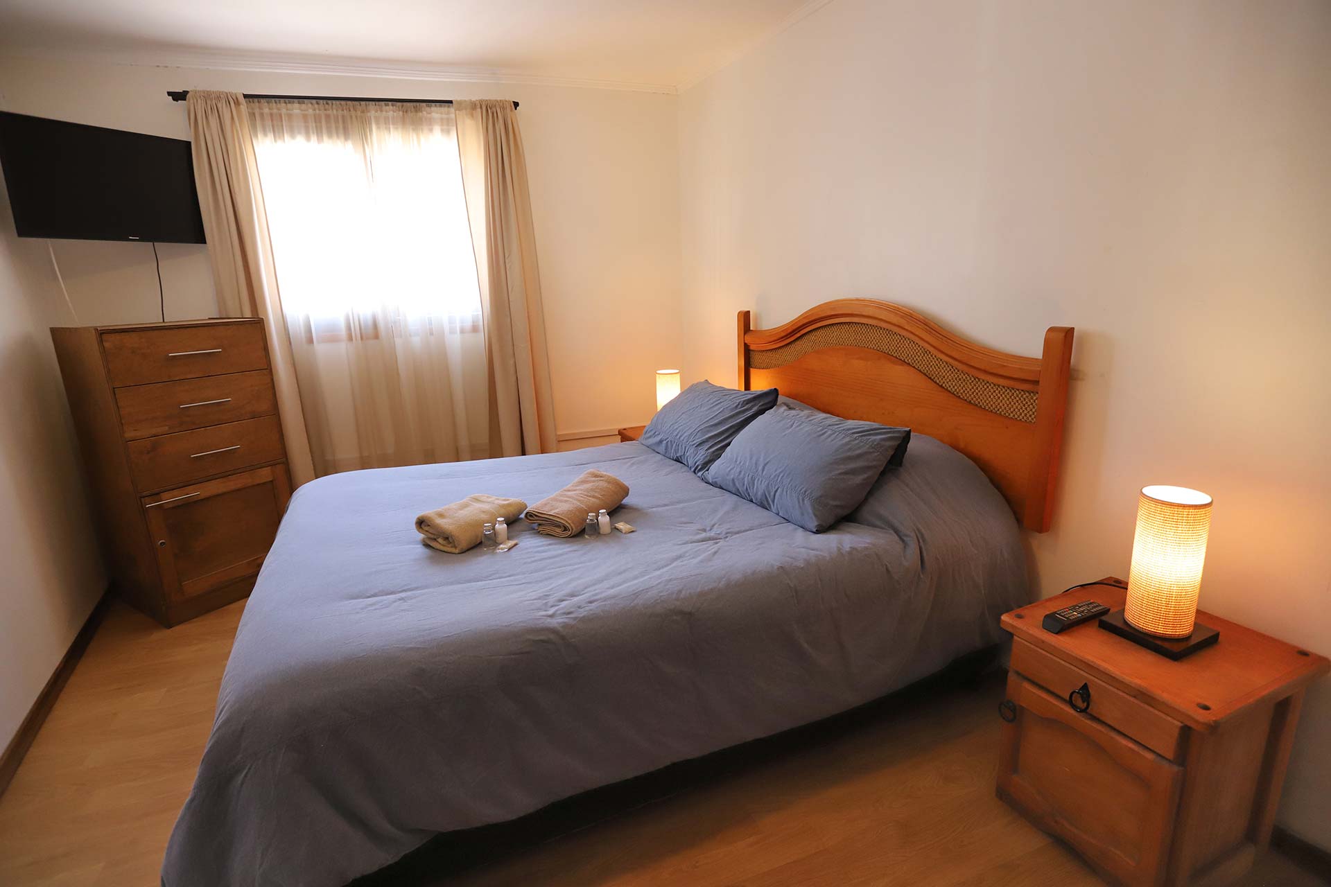 Habitación Matrimonial del Hostal La Serena con cama de plaza y media, TV y velador