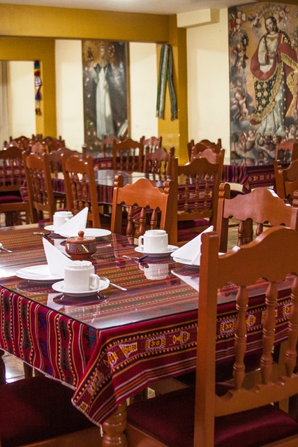 Comedor del Hostal Santa Rosa de Lima con mesas vestidas en textiles andinos