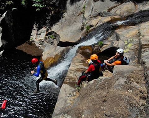 Grupo practicando barranquismo junto a una cascada cerca de Cuenca