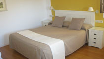 Habitación Superior del Hostal Tabanqueta con cama, cabecero acolchado y mesa de trabajo
