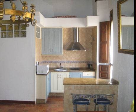 Apartamento con cocina equipada del Hostal Tabanqueta, con vitrocerámica, microondas y barra alta