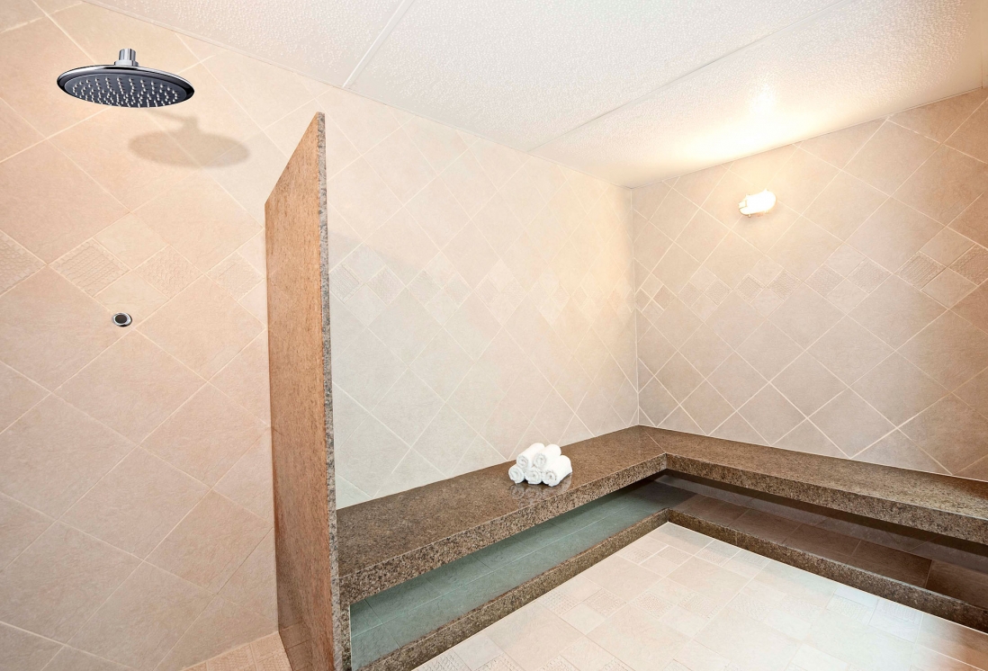 Sauna do Hotel Beira Mar com bancada em granito e toalhas