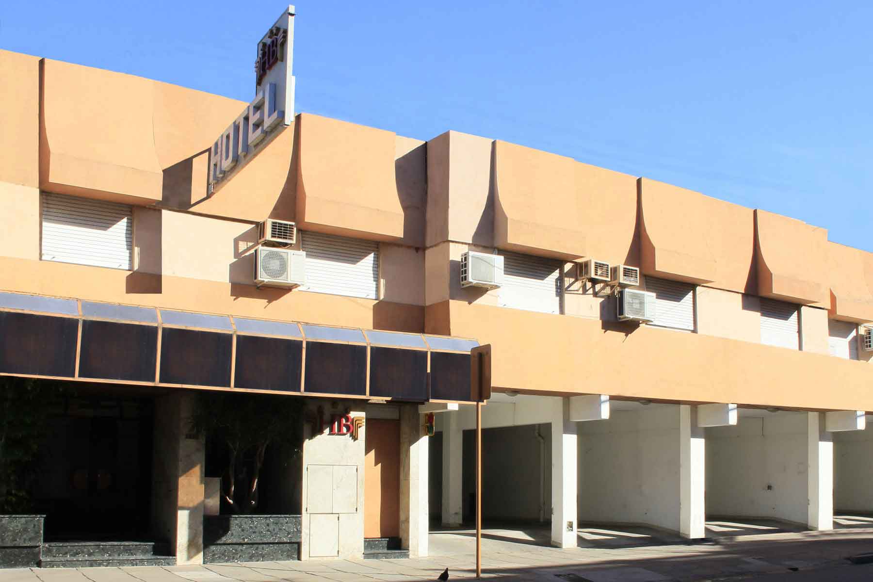 Fachada del Hotel Bertaina con cartel HOTEL y logo HB, entrada cubierta con cochera para vehículos