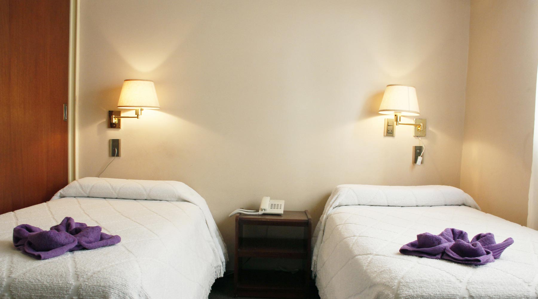 Habitación del Hotel Bertaina con cortinas claras y luz natural de ventana