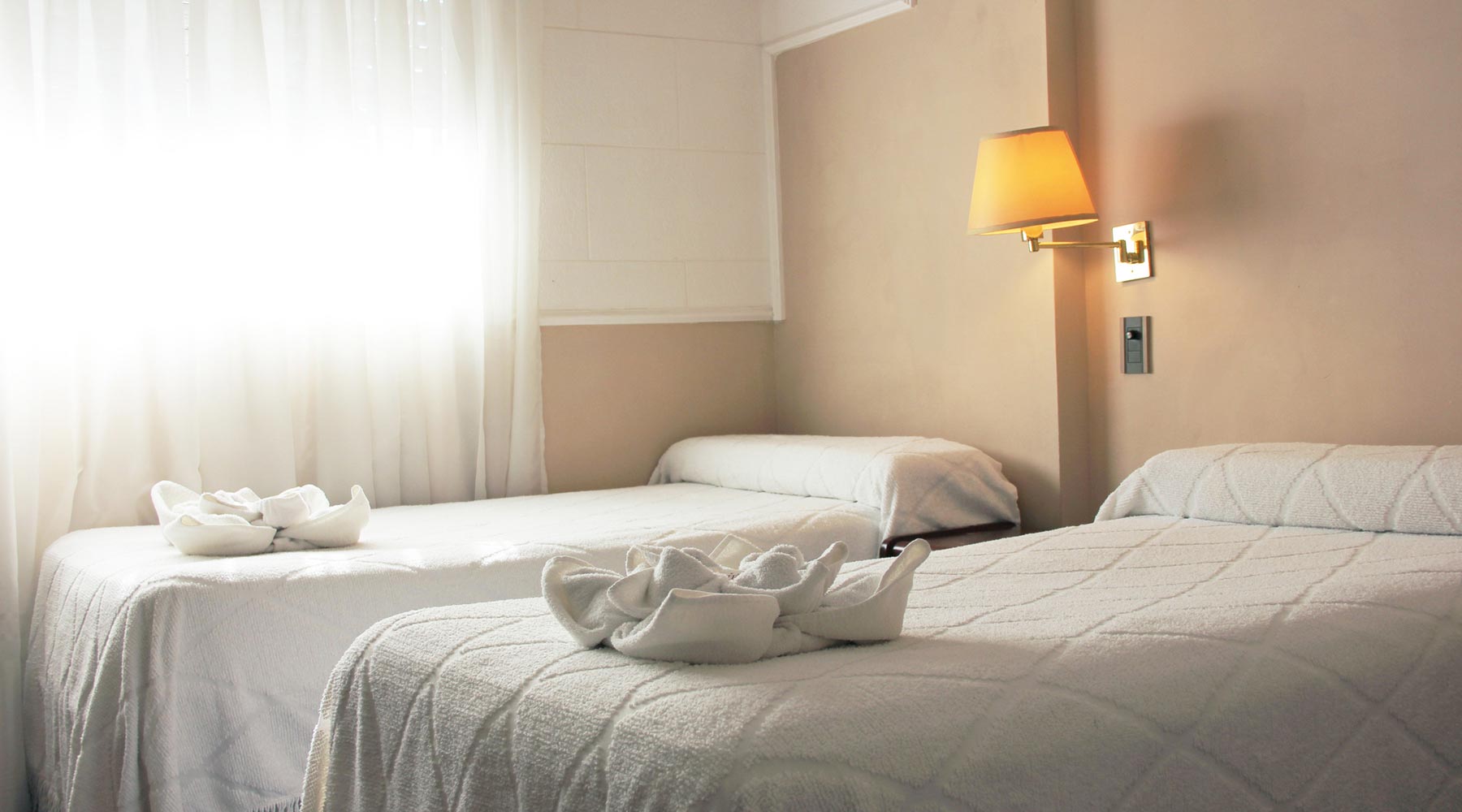 Habitación Doble Standard del Hotel Bertaina con dos camas y toallas dobladas en forma de flor