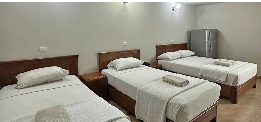 Habitación amplia del Hotel Euro con varias camas y nevera ejecutiva