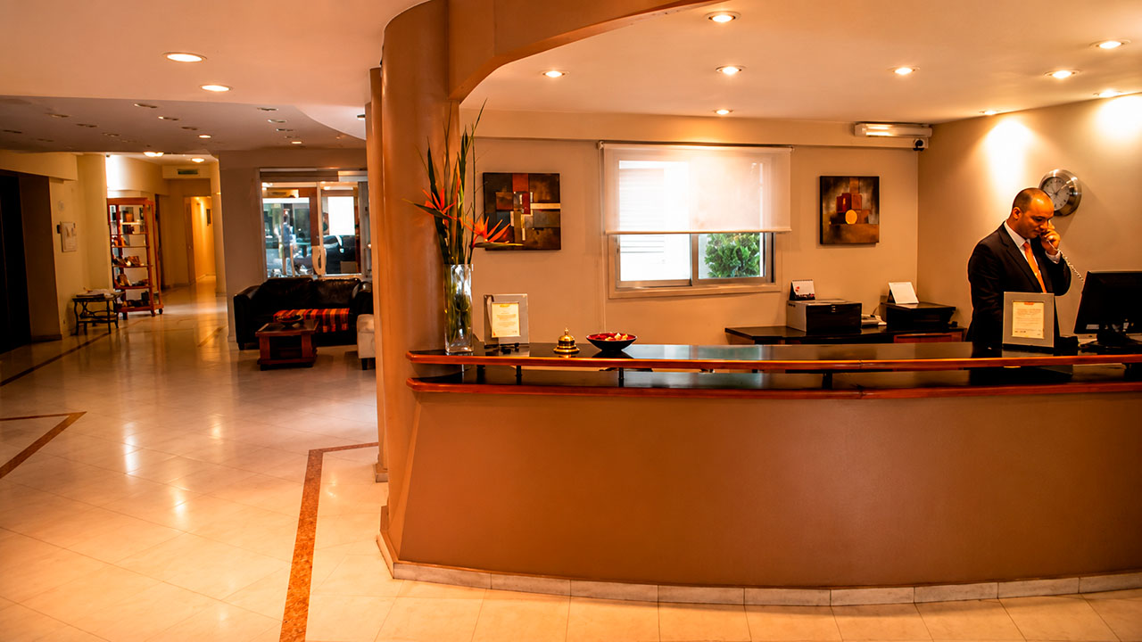 Recepción del Hotel Hernandarias con personal atendiendo el teléfono