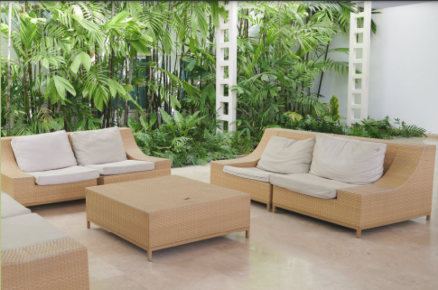 Área de estar del Hotel Kristoff con sofás y jardín tropical