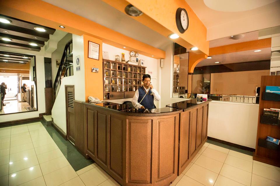 Recepción del Hotel Riobamba Inn con mostrador de madera