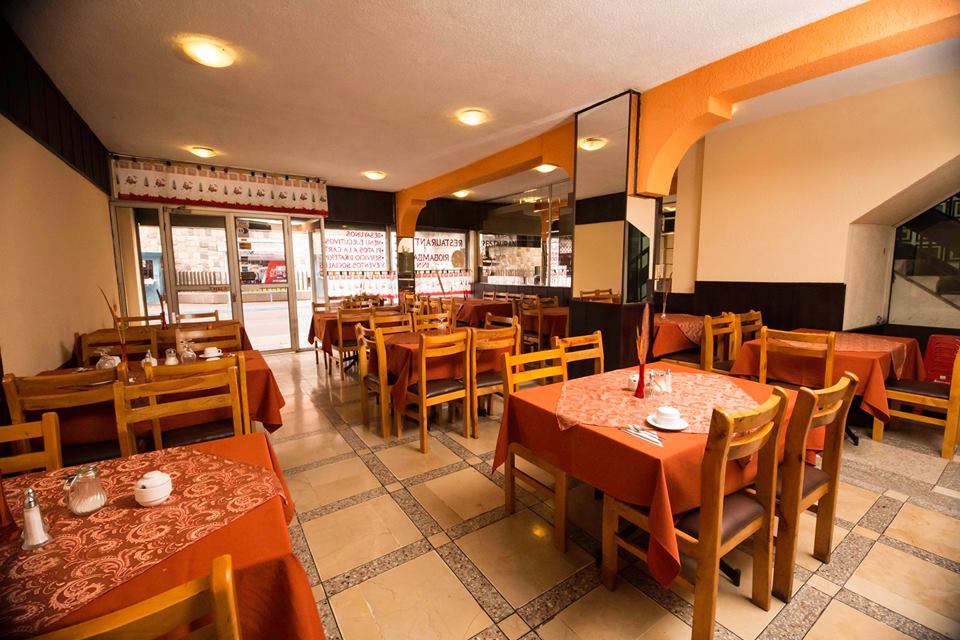 Comedor del restaurante del Hotel Riobamba Inn con mesas vestidas en tonos naranja