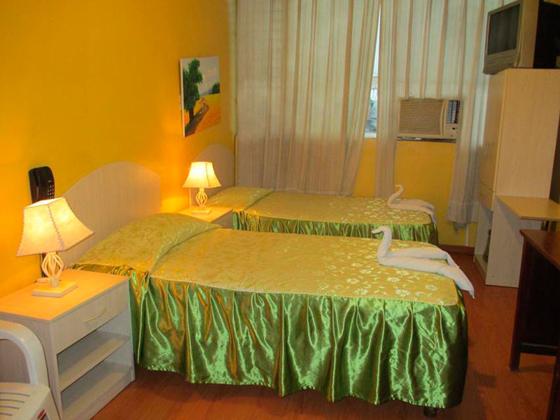 Habitación doble del Hotel Tarapoto Inn con camas, teléfono y televisor