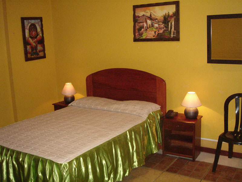 Habitación Matrimonial del Hotel Tarapoto Inn con cama de dos plazas, veladores con lámparas y teléfono