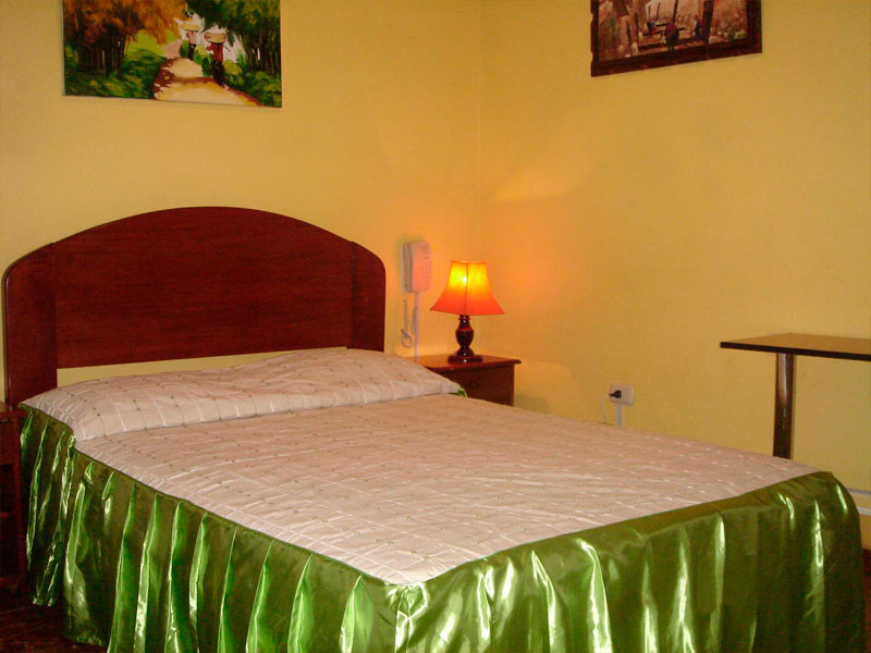 Habitación Simple del Hotel Tarapoto Inn con cama de una plaza, cuadros en la pared y espejo